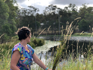 woman picks flowers in nature with dam flowers grasses foraging fleurs